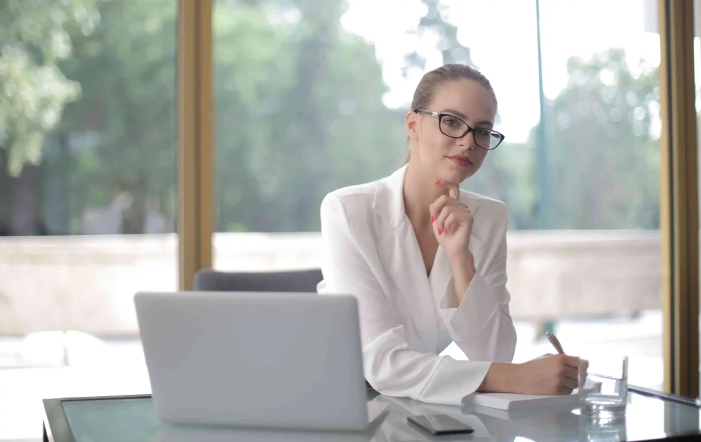 Een zelfverzekerde interim professional aan het werk op een laptop in een modern kantoor, symbool voor de strategische inhuur flexibele schil overheid.