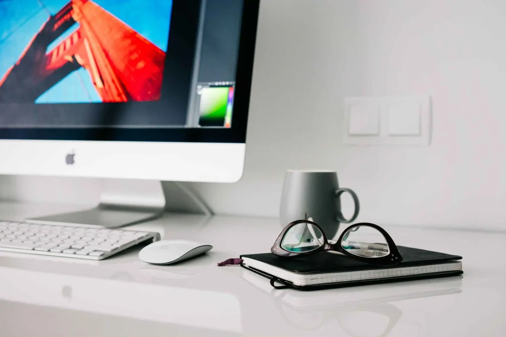 Modern minimalist freelance workspace with notebook and glasses, a professional setting for handling complex administrative tasks like VGB vs. VOG aanvragen voor ZZP
