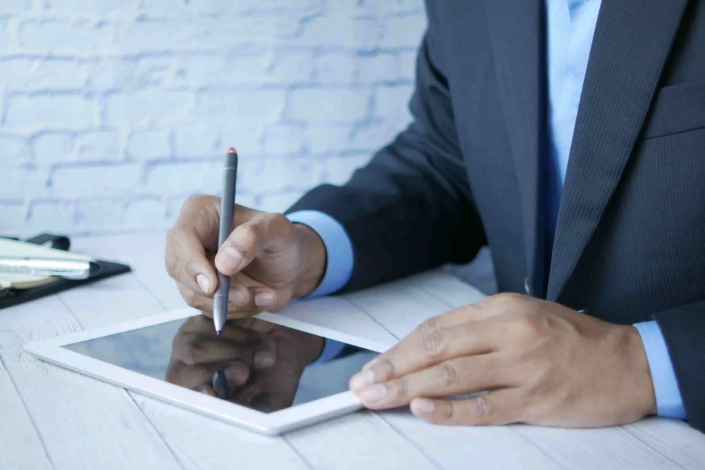 Een zelfstandige professional controleert een digitaal raamcontract op een tablet op basis van de regels in de Nederlandse aanbestedingswet voor overheidsopdrachten.
