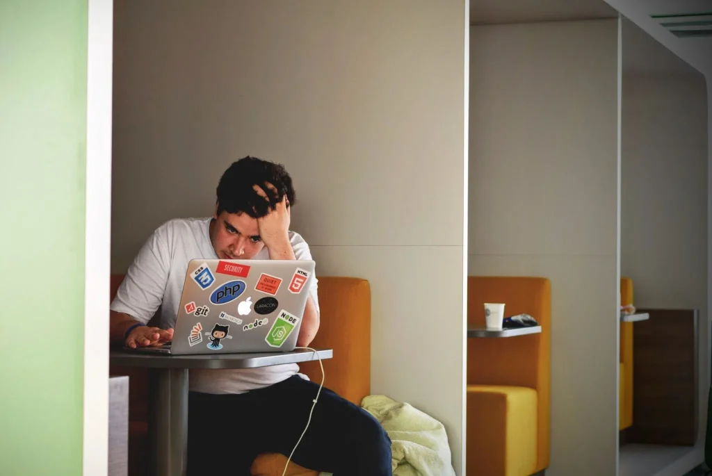Een persoon kijkt gestrest naar een laptop op kantoor naar aanleiding van de impact van de schademonitor zzp.