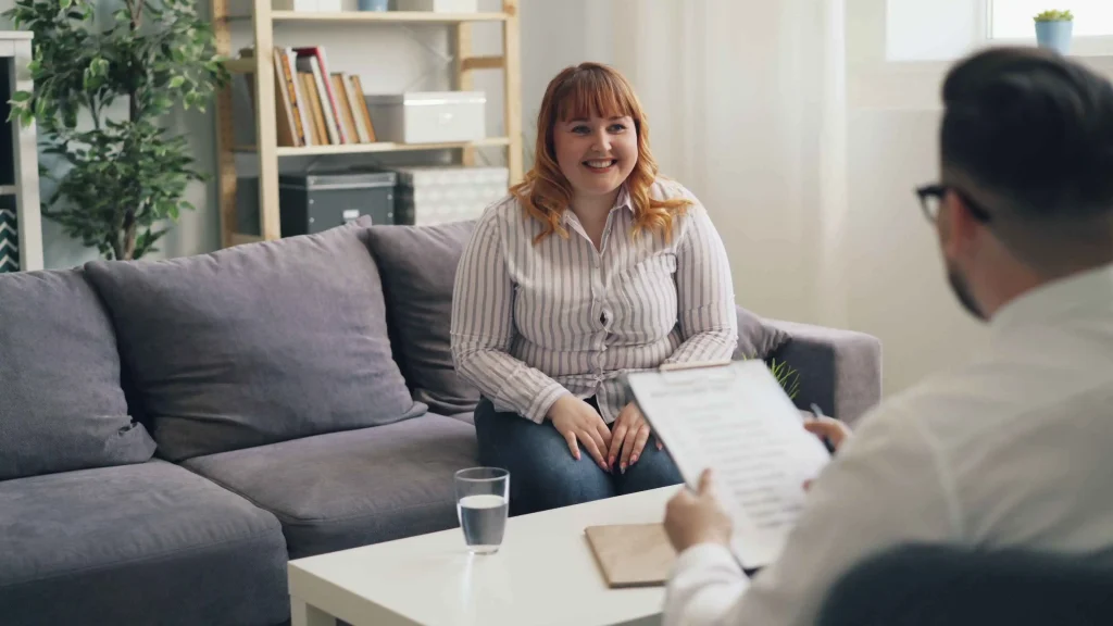 Een consulent integrale toegang voert een ondersteunend gesprek met een inwoner aan de keukentafel.