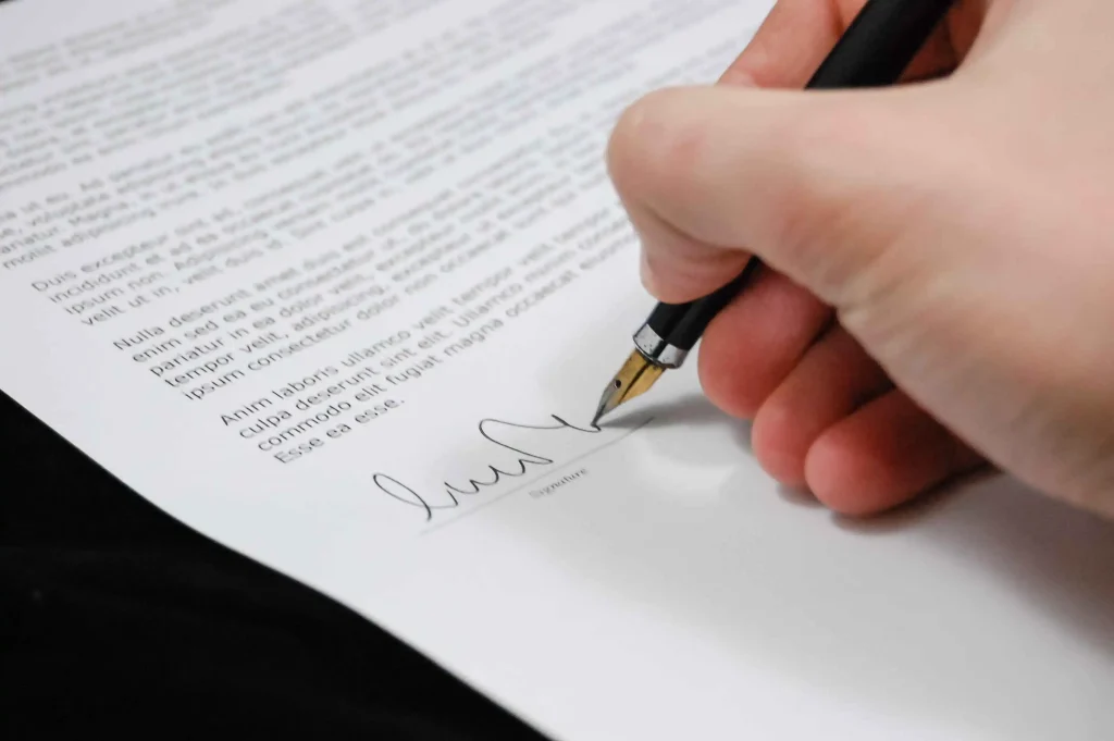 Handen die een zakelijk contract ondertekenen voor een opzegtermijn zzp opdracht