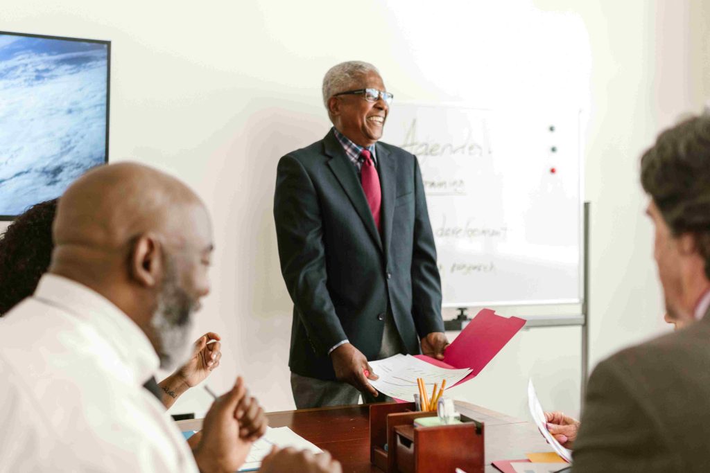 Wat is een interimmanager: ervaren tijdelijke leidinggevende presenteert strategie tijdens een managementvergadering.